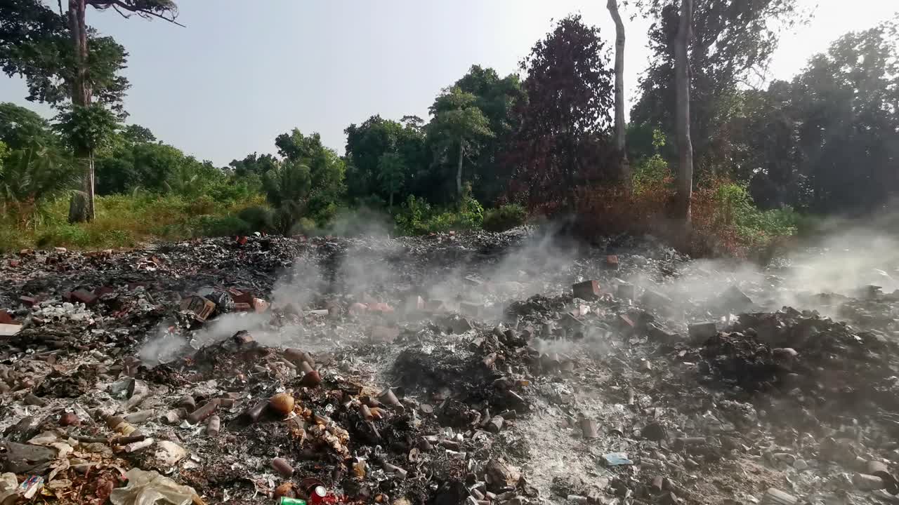 Trash landfill that is still burning lets of smoke into the atmosphere in India on a remote island in the Andamans.