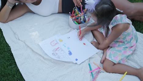 mother and daughter drawing together outside