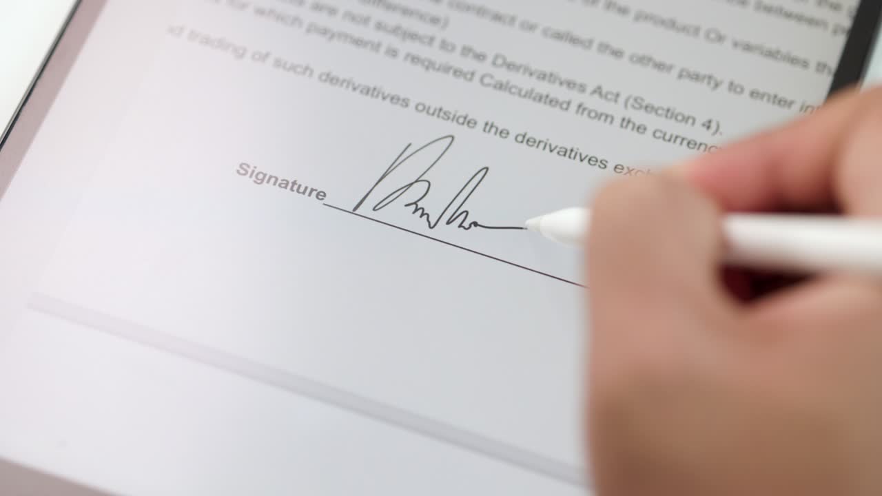 Businessman signing a business contract with stylus pen on tablet. Man signing contract on tablet at office. Business and technology concept. Electronic signature concept