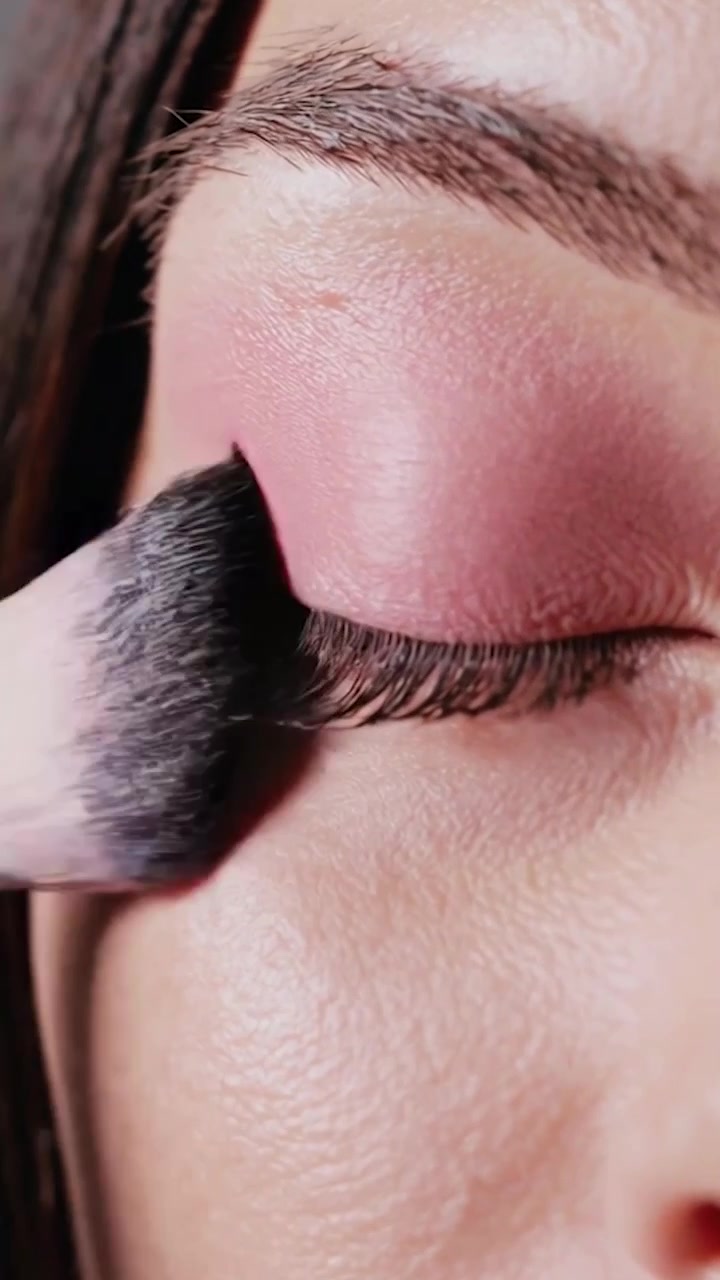 Makeup Artist Applying Pink Eyeshadow with Brush on Woman's Eyelid