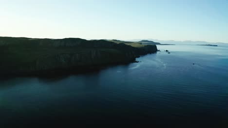 aerial over deep blue waters off cliffs off isle of skye in scotland. parallax view
