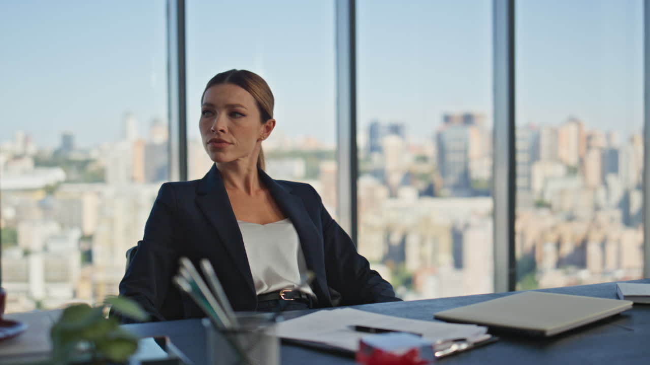 Bored worker tapping desk in modern office. Beautiful businesswoman thinking
