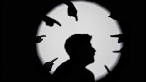silhouette of a person being accused or judged by multiple pointing hands