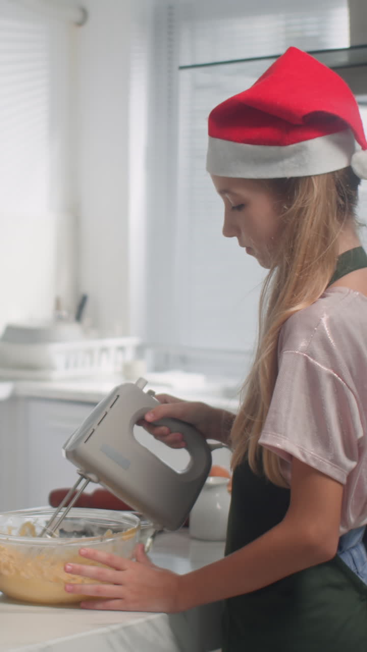 Teenage Girl in Christmas Hat Mixing Dough in Bowl