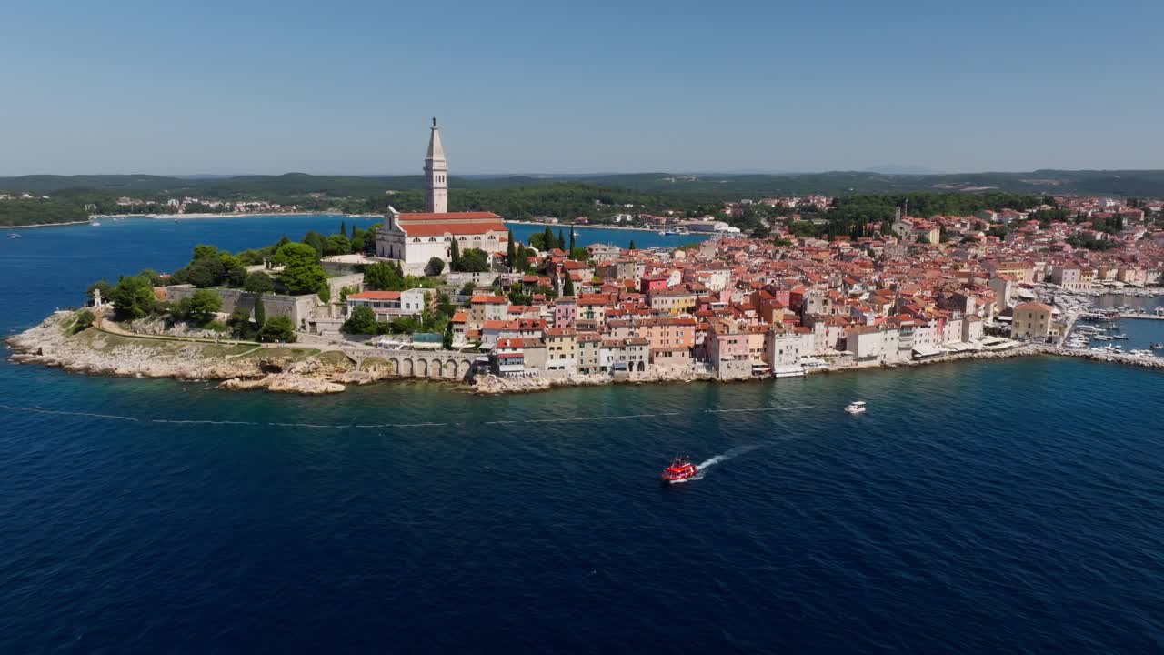 Luftfoto av en båt som forlater gamlebyen i Rovinj, en berømt middelaldersk kroatisk by ved sjøen