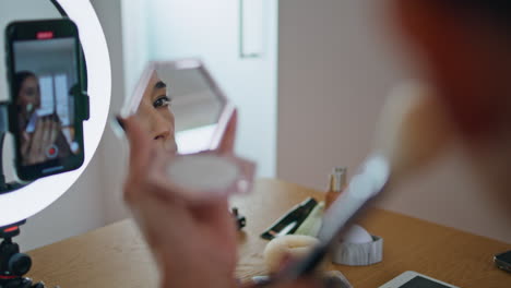 woman visagiste applying cosmetics at mirror close up. blogger recording visage