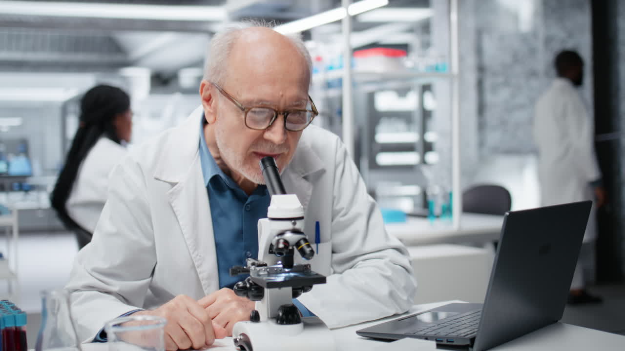Portret van vrolijke onderzoeker die genetisch monster analyseert met microscopische apparatuur.