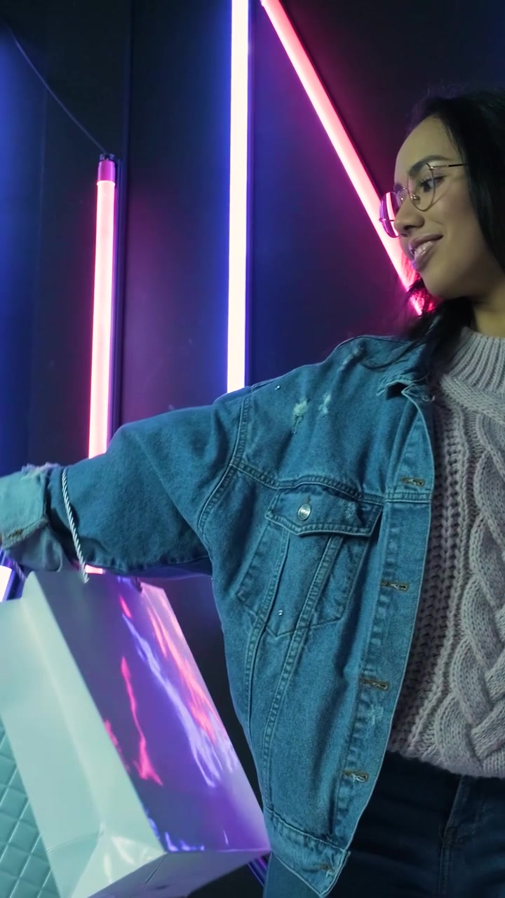 Neon Işıkların Önünde Alışveriş Çantasıyla Poz Veren Genç Kadın