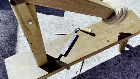 Blunt hacksaw sits below weathered worn bench in lonoa spain festival