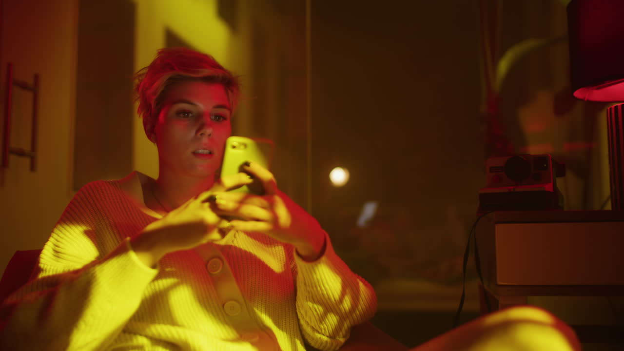 Woman interacting with a phone and a camera in a brightly lit room