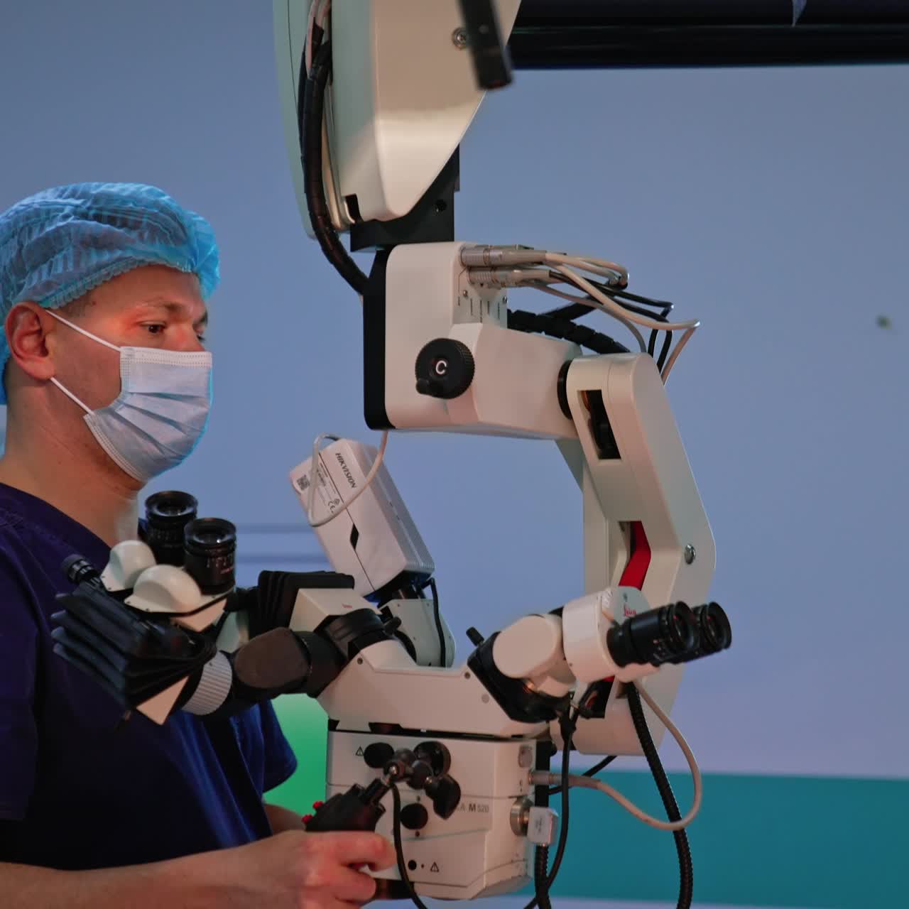 Doctor moving the powerful technological microscope hanging from the wall. Surgeon adjusting the equipment to be used at operation