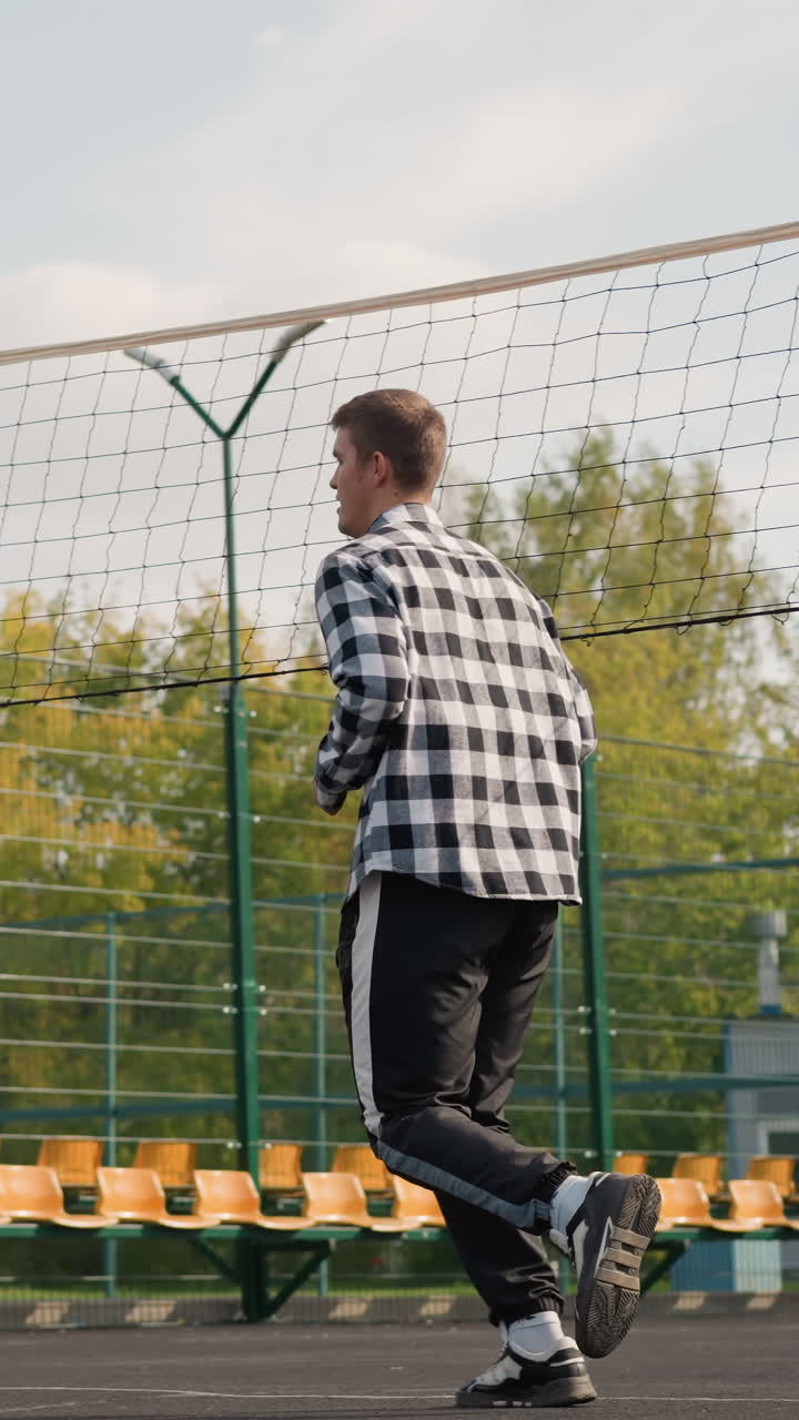 entrenador guiando a los atletas en la cancha de voleibol al aire libre mientras corren, el cabello se balancea, con vegetación en el fondo, capturando el movimiento atlético en la sesión de entrenamiento deportivo