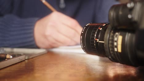 a person draws a storyboard at a table with a camera and crayons