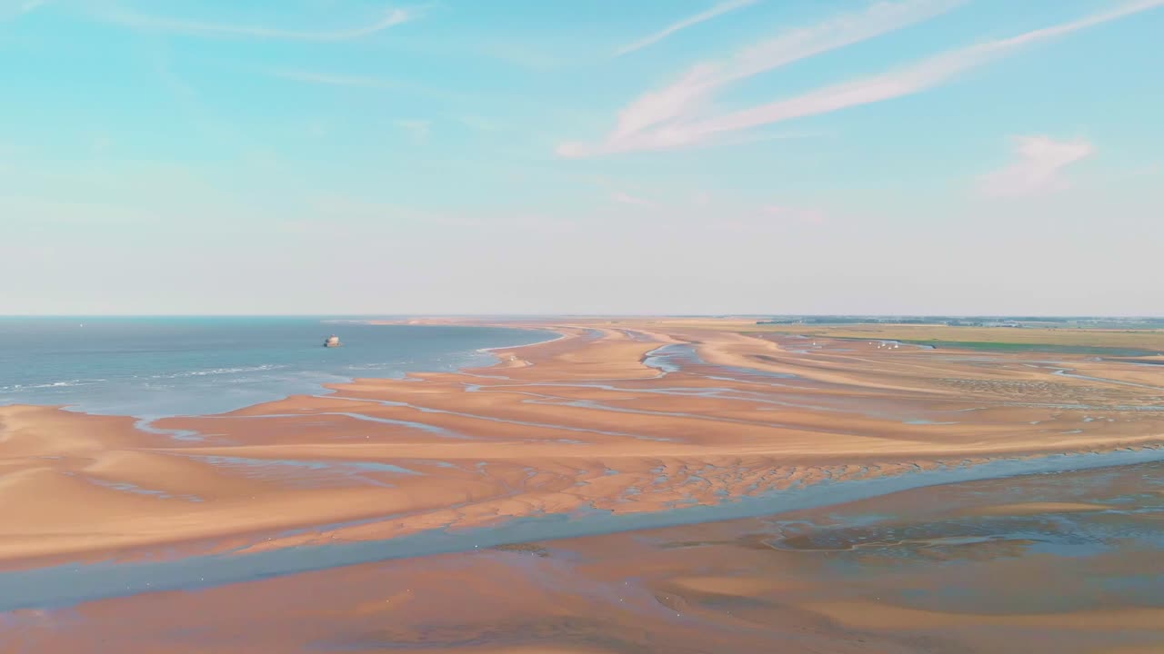 Aerial footage of Holkham Beach's expansive sand dunes and coastline in soft, golden hour light. Capturing the tranquil beauty of Norfolk's stunning, unpopulated seascape