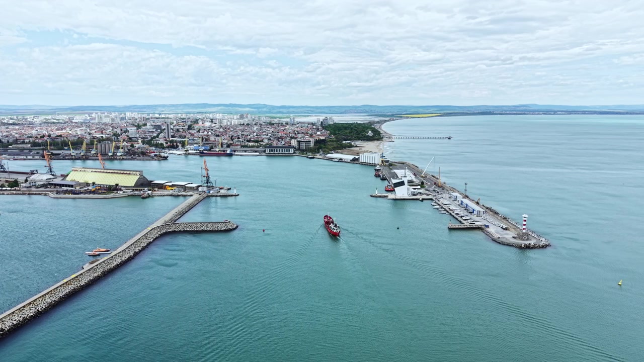 Vista dell'area portuale con barche e banchine di carico vicino a una città costiera in una giornata limpida