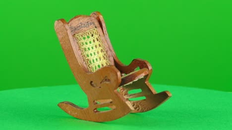 miniature mini scale wooden rocking chair handmade handcraft in a turntable with green screen for background removal 3d