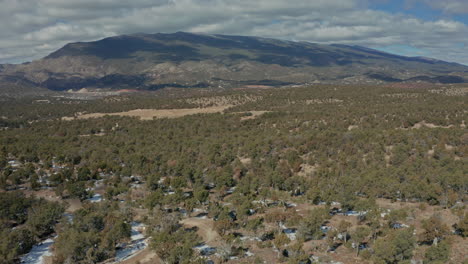 Orbiting-daytime-aerial-of-car-parked-in-remote-desert-wilderness,-4K