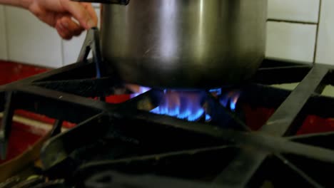 male baker lighting gas with stick in bakery shop 4k