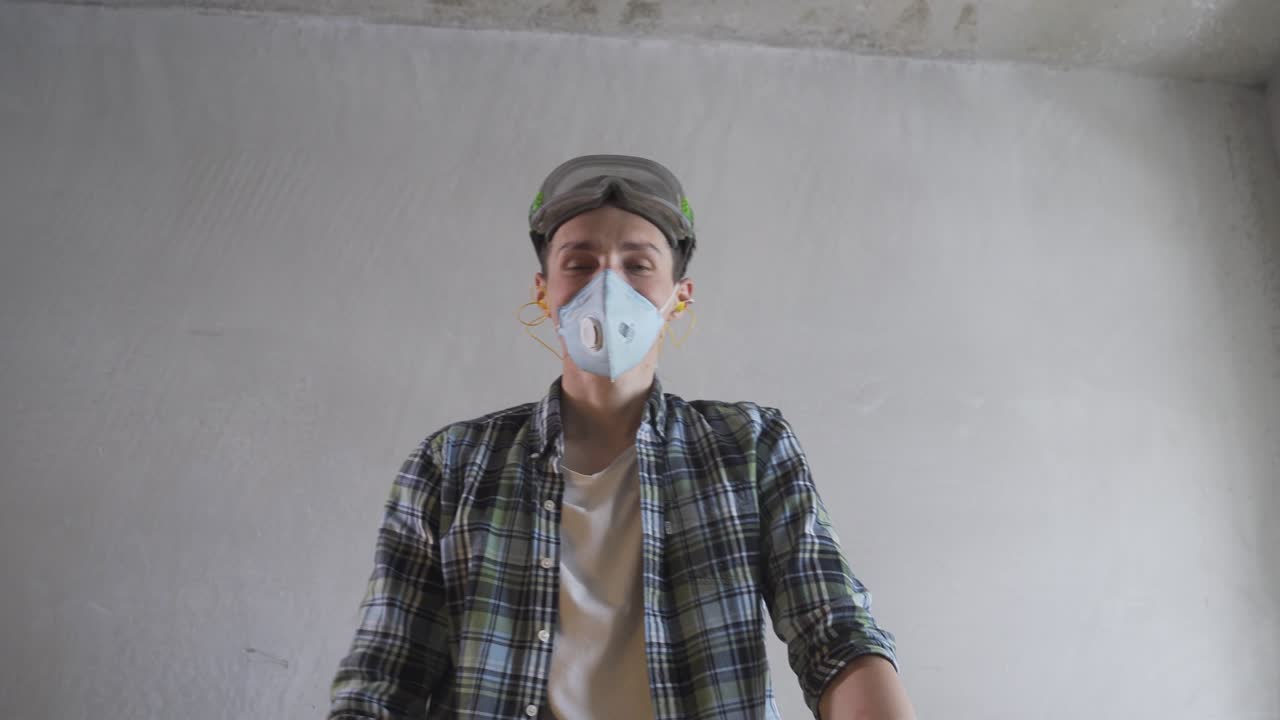 마스크와 고글을 입은 목공은 밀러와 함께 일하며 카메라를 쳐다본다.