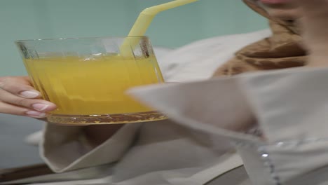 una mujer bebiendo jugo de naranja.