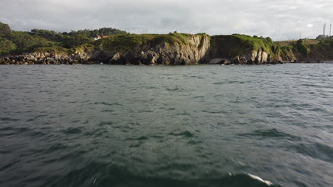 Drone-flying-over-the-sea,-approaching-to-a-rocky-coast