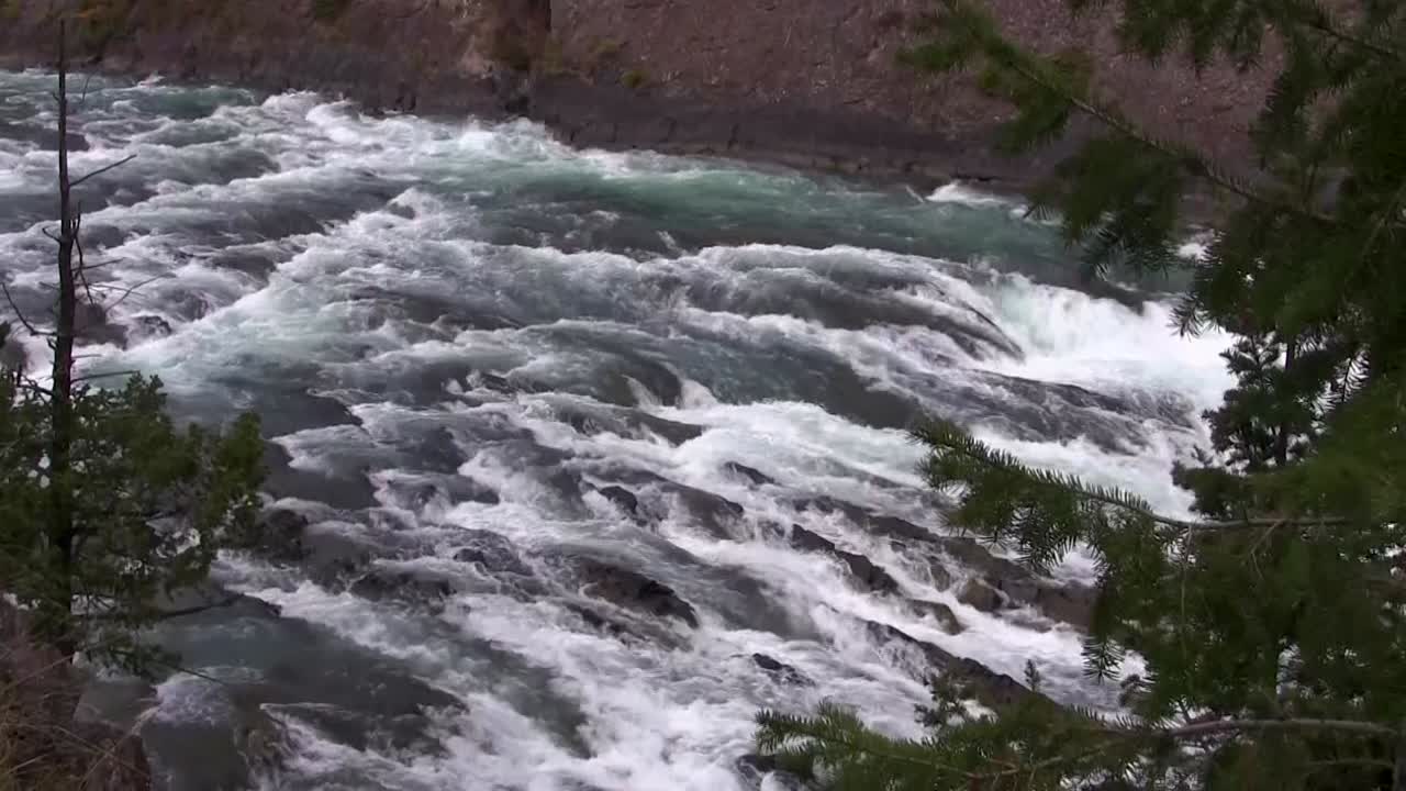 Descending view of a mountain into raging white water rapids