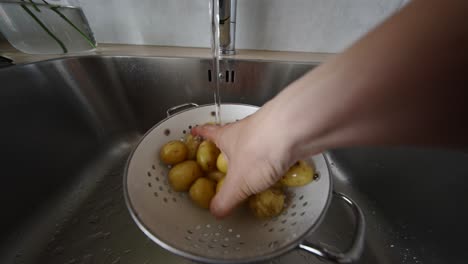 lavando patatas en el fregadero de la cocina