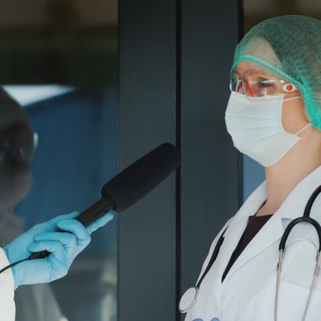 médico da una entrevista a un reportero ambos en trajes de protección 1