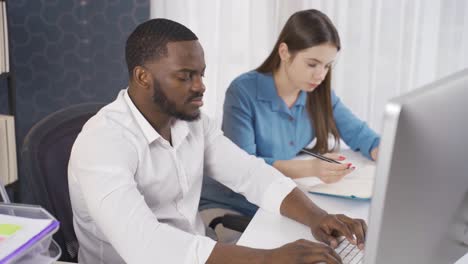 serious multi-ethnic young man and woman working together in business office.