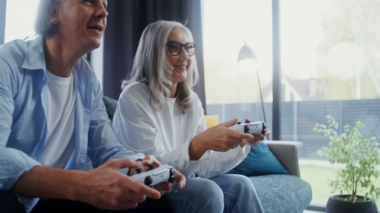 Senior couple playing video games at home