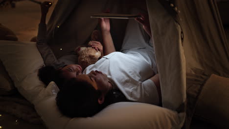 mother and daughter enjoying story time in a tent