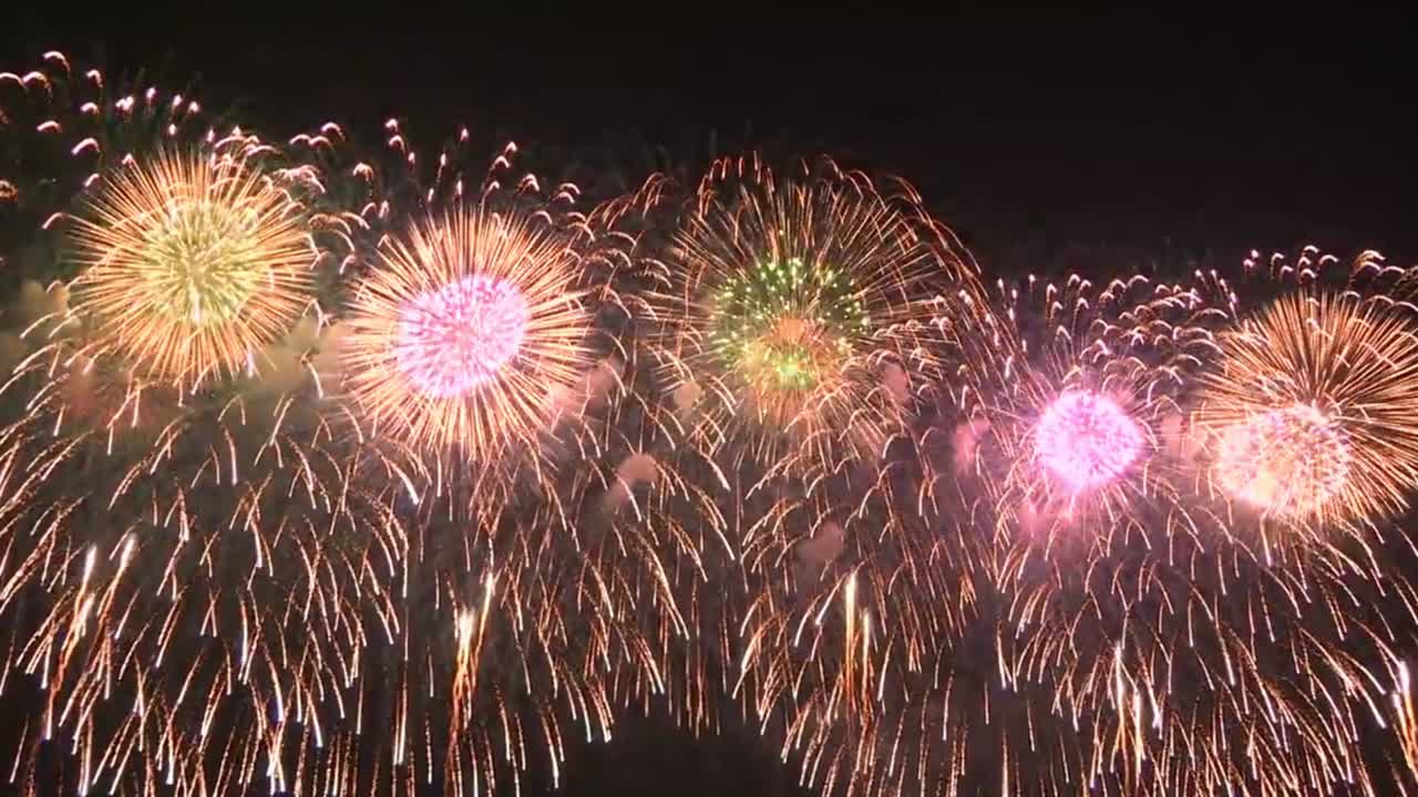 Synchronised fireworks celebration in the night sky.