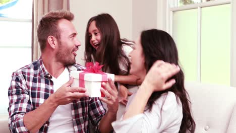 cute girl surprising her parents with gift