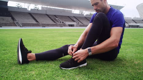 athlete tying shoes at a stadium