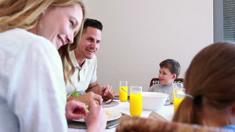 Glückliche-Junge-Familie-Im-Gespräch-Am-Esstisch