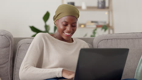 Laptop,-typing-and-black-woman-on-a-sofa-working