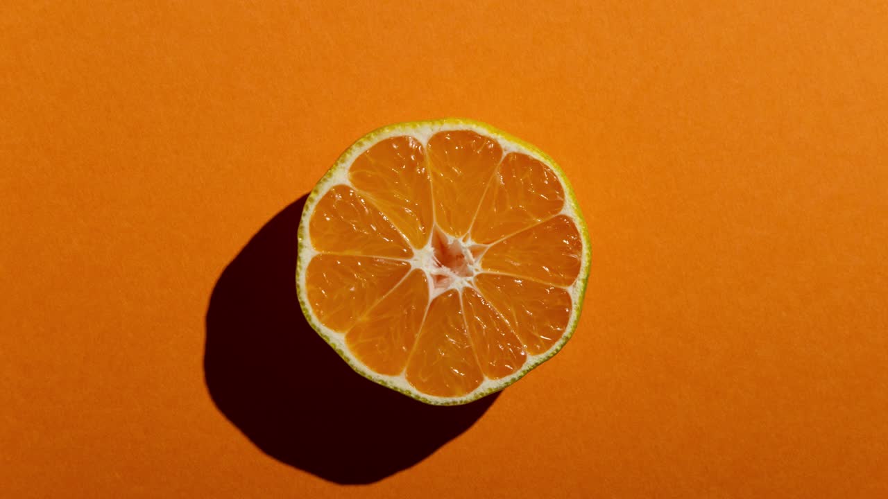 mitades de mandarina frescas con una fuerte sombra en un fondo blanco, verde y naranja. animación de movimiento de parada