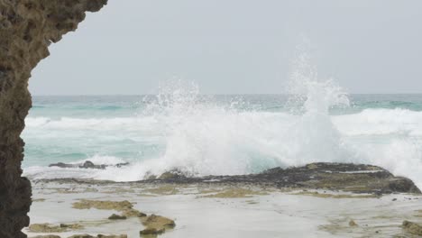 Wide-slow-motion-shot-of-wave-crashing-onto-rock