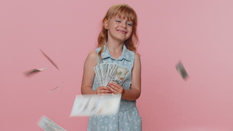 Money-cash-dollar-rain-falling-on-child-girl-kid-celebrating-success,-winning-lottery-jackpot-luck