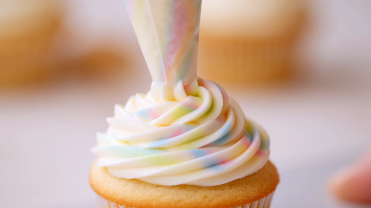 Decorating a Cupcake with Swirled Pastel Icing from a Piping Bag