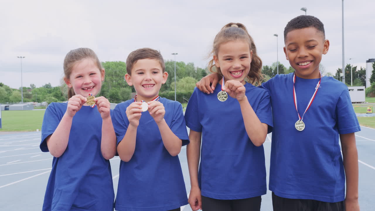 retrato de niños mostrando las medallas de los ganadores en el día del deporte