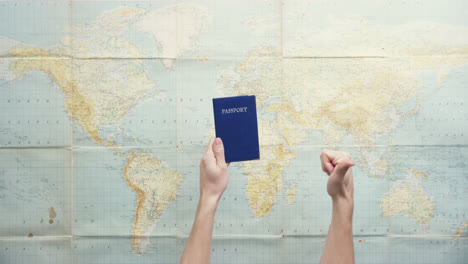 Top-view-hands-holding-american-passport-thumbs-up-gesture-vintage-world-map-from-above---Red-Epic-Dragon