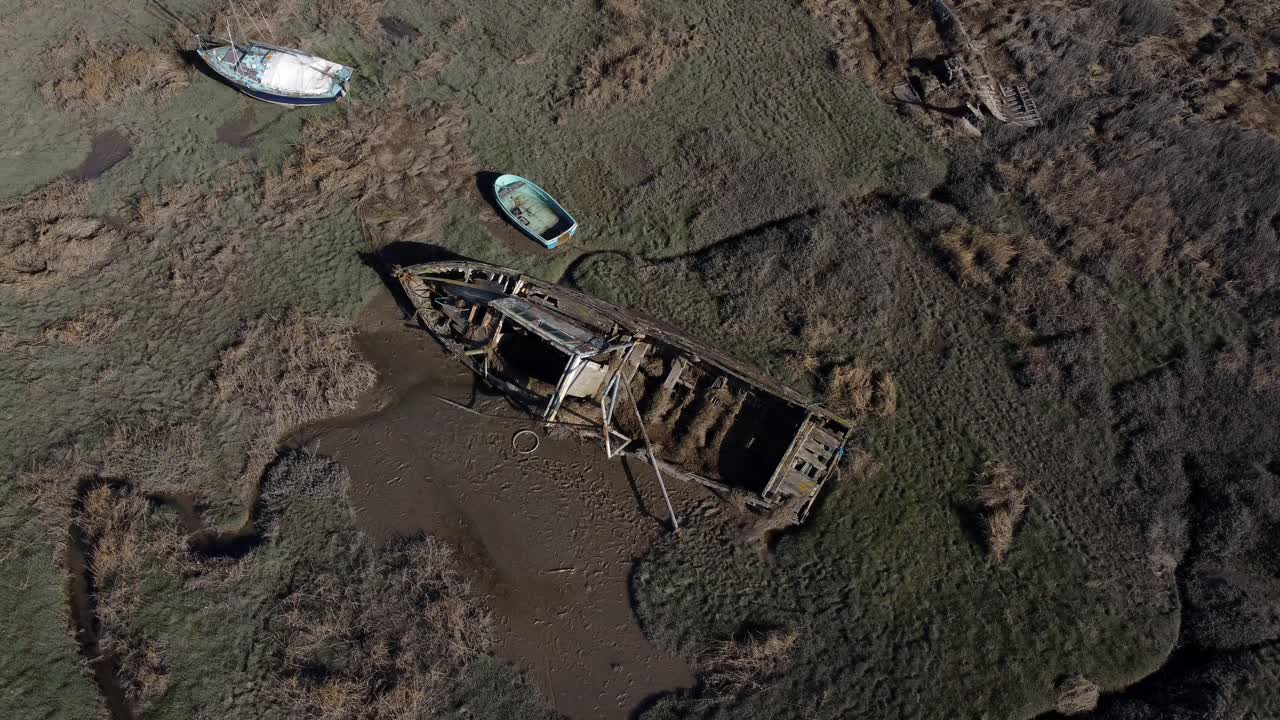 astillero de naufragio de barco de pesca abandonado de madera desgastada en barro de pantano vista aérea de la costa de marea baja