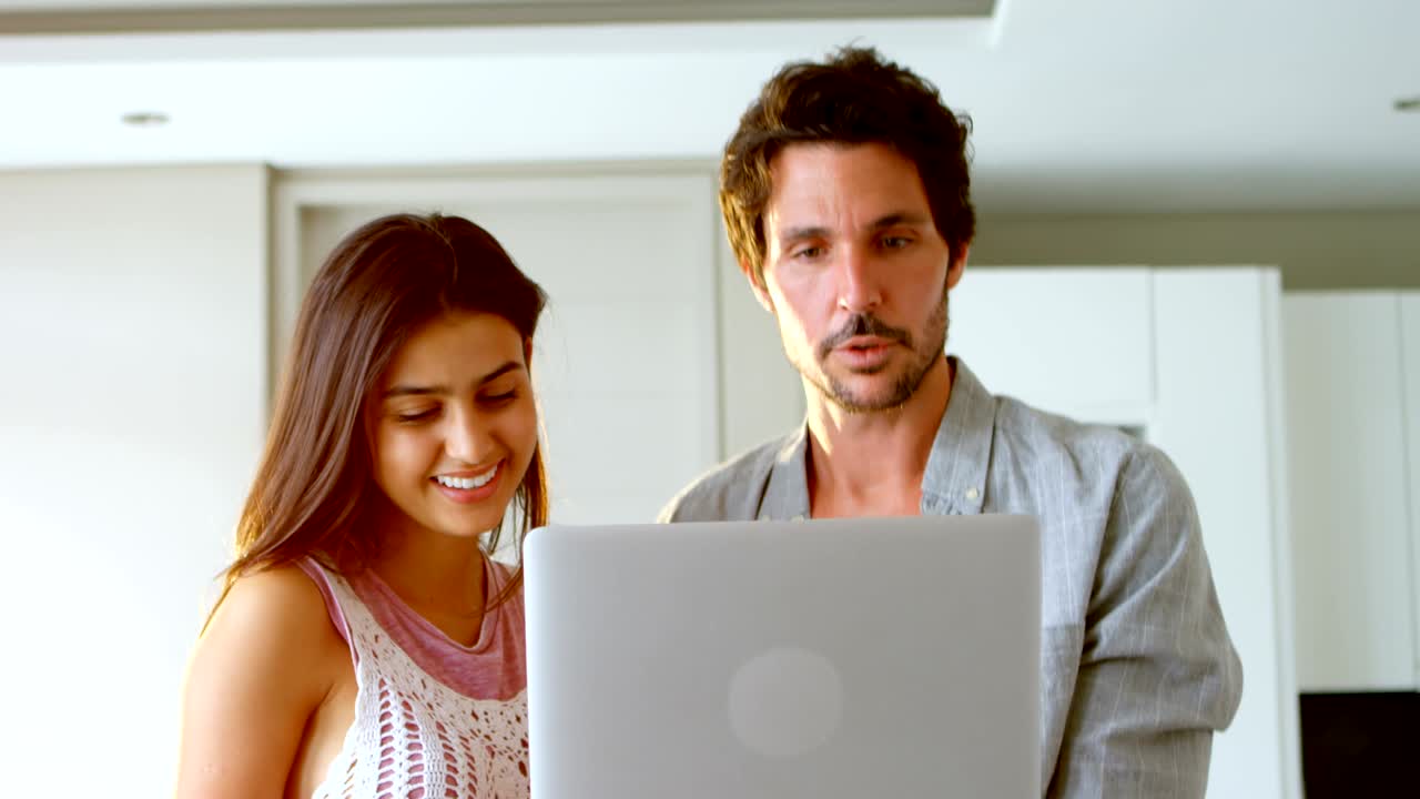 pareja usando una computadora portátil en casa 4k