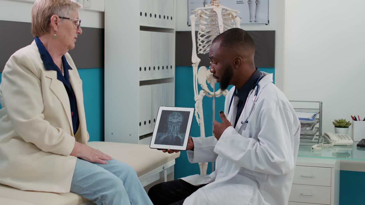 Doctor examining elderly patient's X-ray during medical consultation