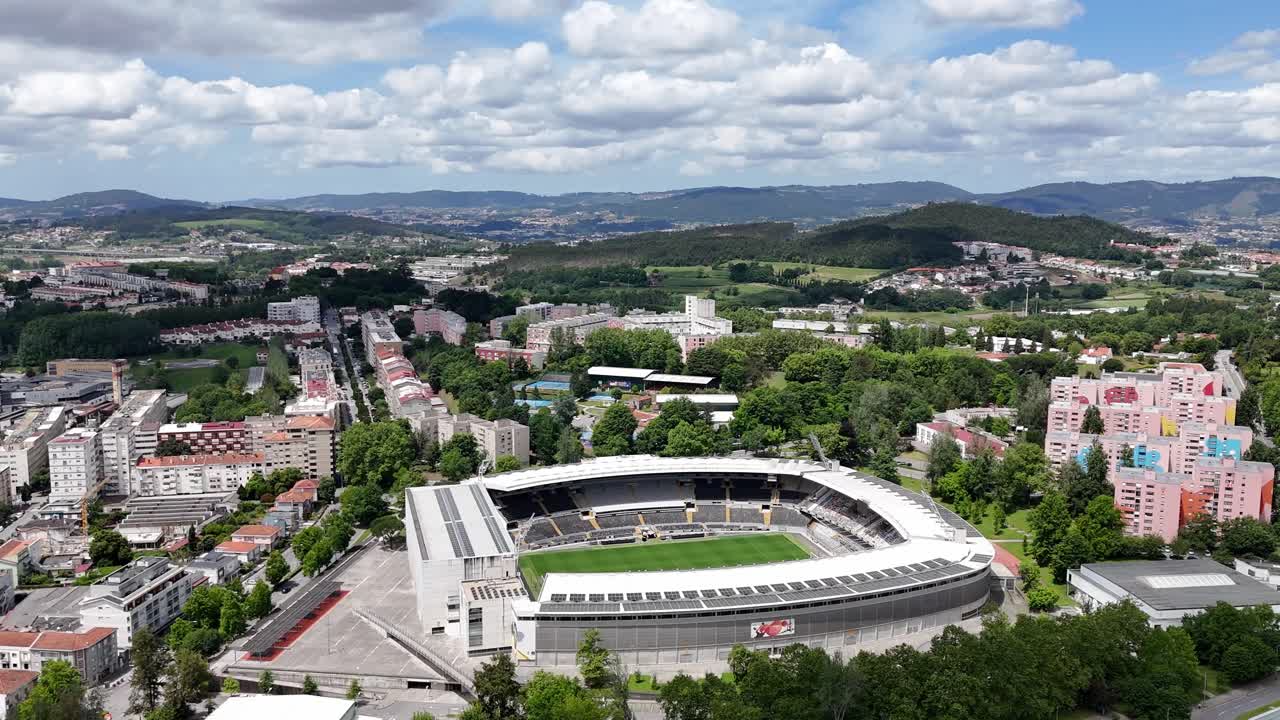 Aerial - Wide view of Estádio D. Afonso Henriques in Guimarães, Portugal, surrounded by cityscape and green hills