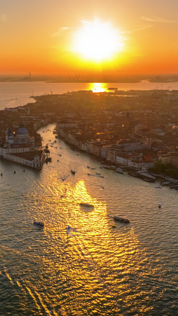 Aerial drone view of boats moving near Venice City, Italy at sunset. Vertical