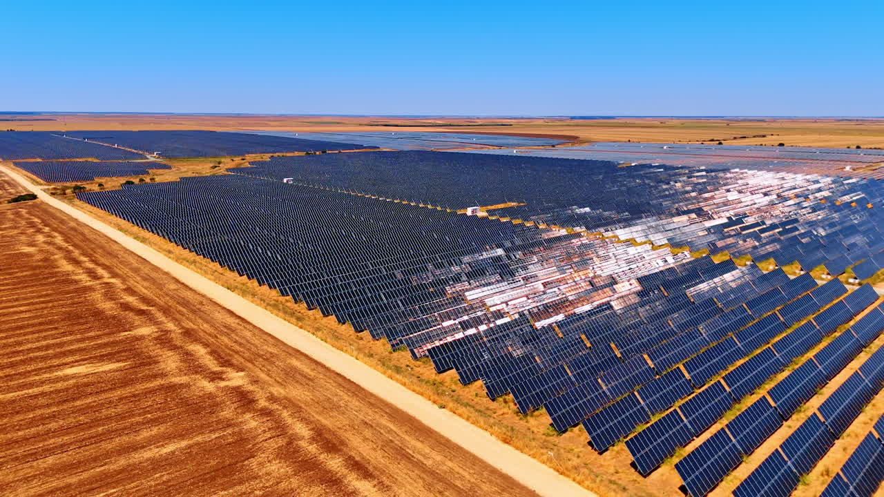 Flight over the bare field along the site covered with solar panels. Production of green energy