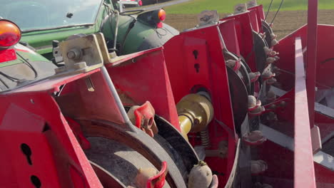 rotating wheels planting potatoes on a farm field behind a tractor