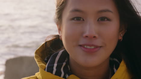 portrait of happy asian woman smiling enjoying sunny day relaxing on summer vacation with wind blowing hair